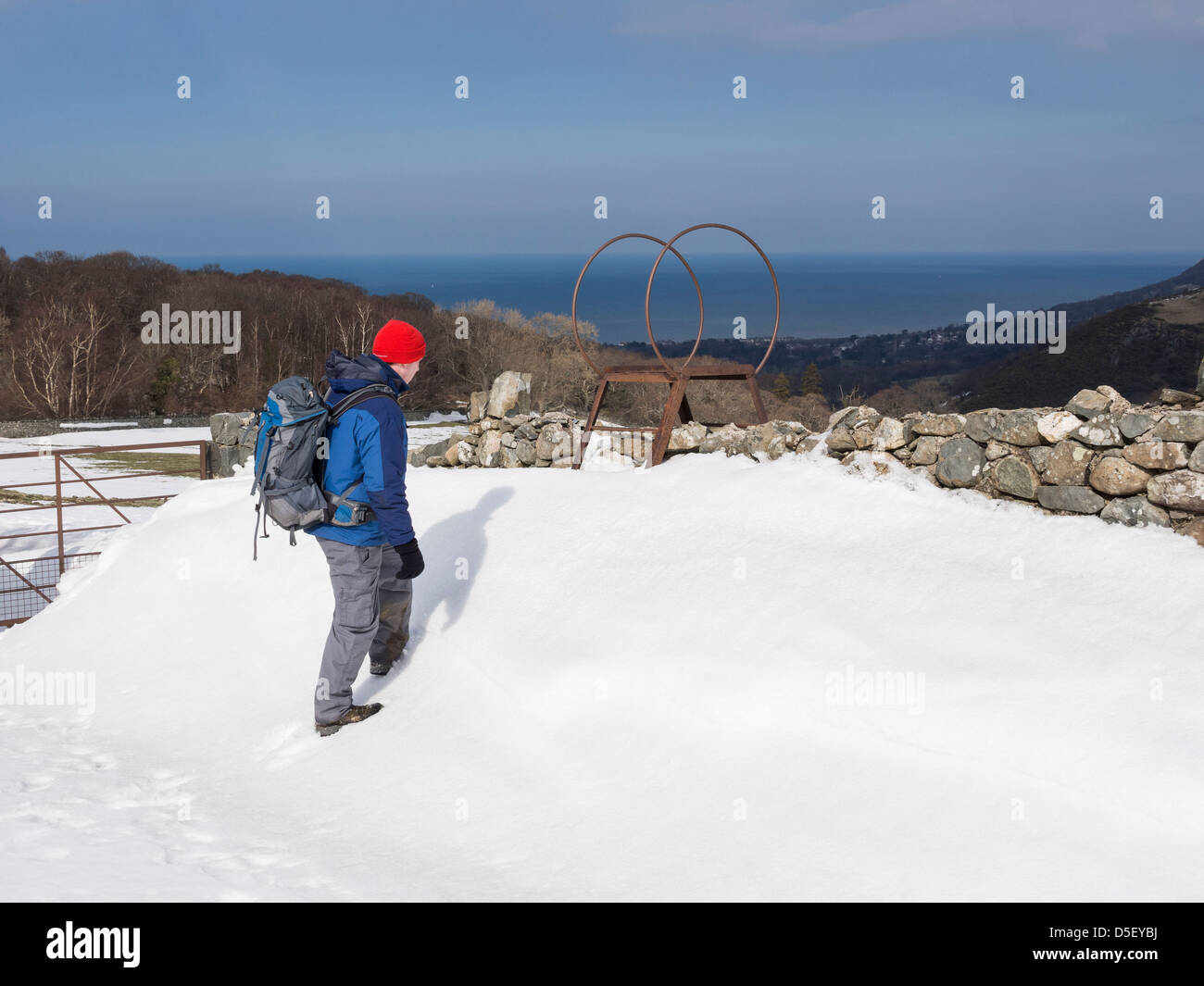 Rambler passeggiate sulla neve profonda deriva dal montante della scala su una parete sul bordo settentrionale del Parco Nazionale di Snowdonia, Galles del Nord, Regno Unito Foto Stock