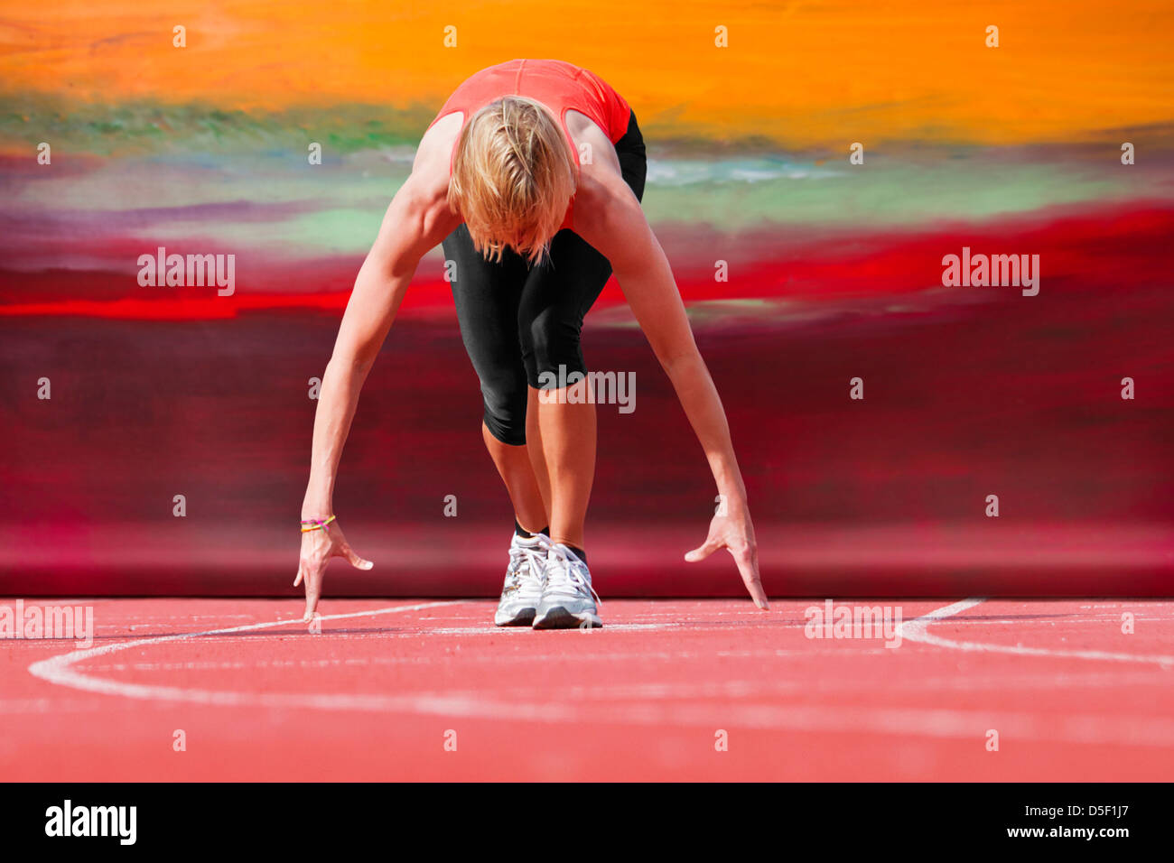 Runner in posizione iniziale con tela in background Foto Stock