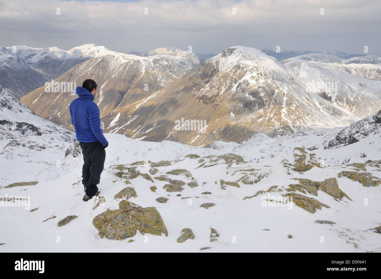 Walker su lunghi Pike, Grande Fine, ammirando il panorama verso il grande timpano in inverno nel Lake District inglese Foto Stock
