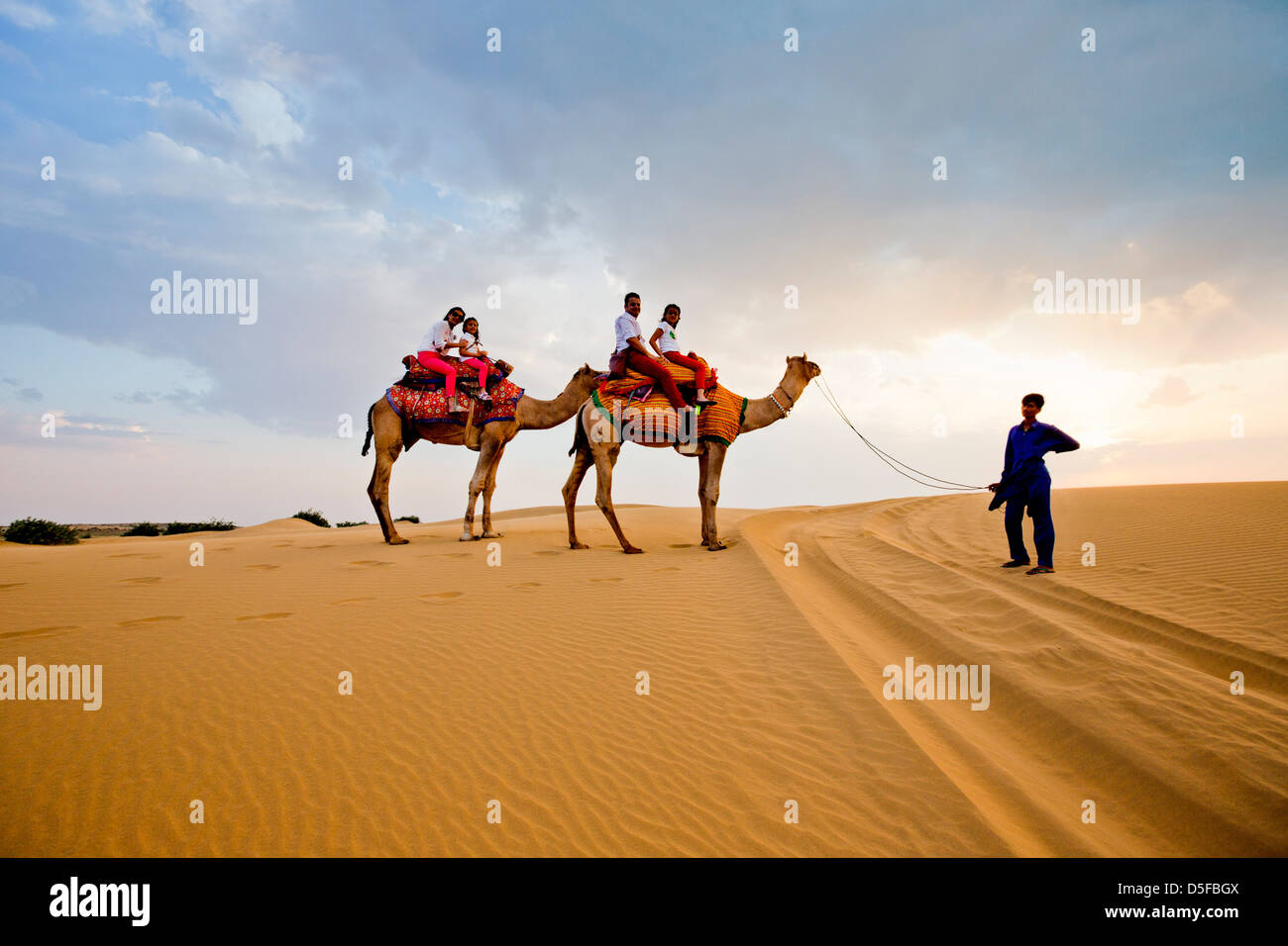 Turisti che si godono il cammello safari nel deserto, il Deserto di Thar, Jaisalmer, Rajasthan, India Foto Stock
