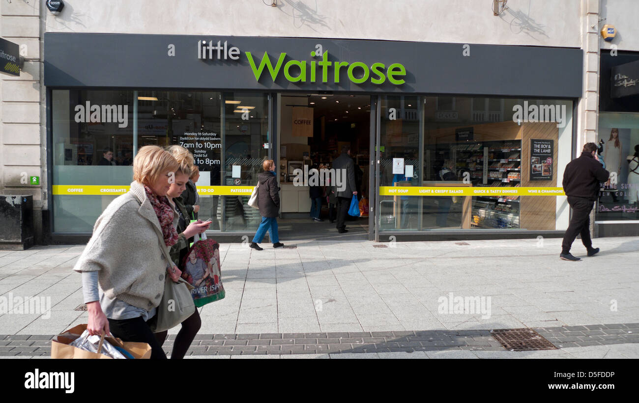 Gli amanti dello shopping a piedi oltre la parte anteriore del piccolo supermarket Waitrose store UK KATHY DEWITT Foto Stock