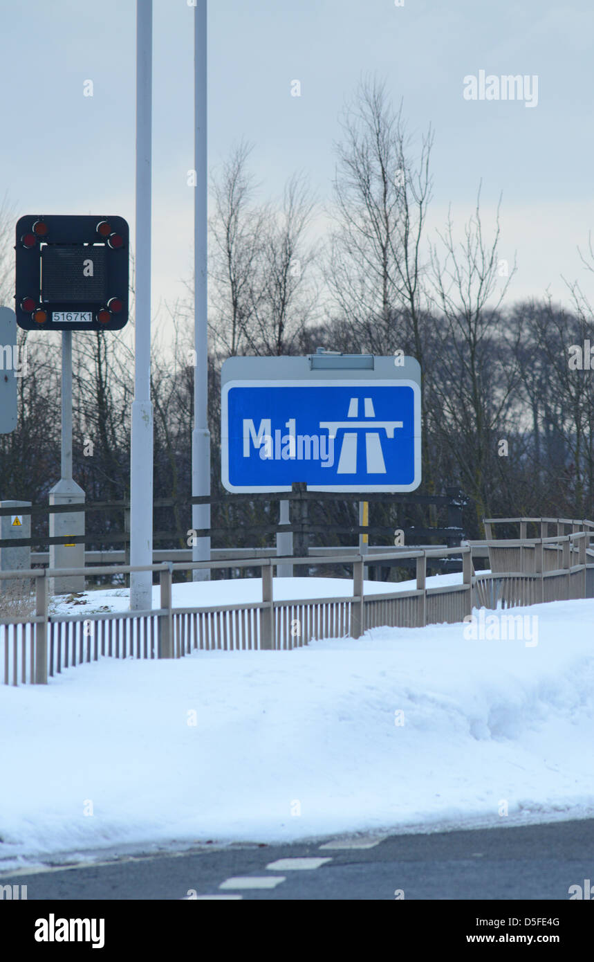 Inizio dell'autostrada M1 a firmare circondato da gigante derive di neve nelle vicinanze Leeds Yorkshire Regno Unito Foto Stock