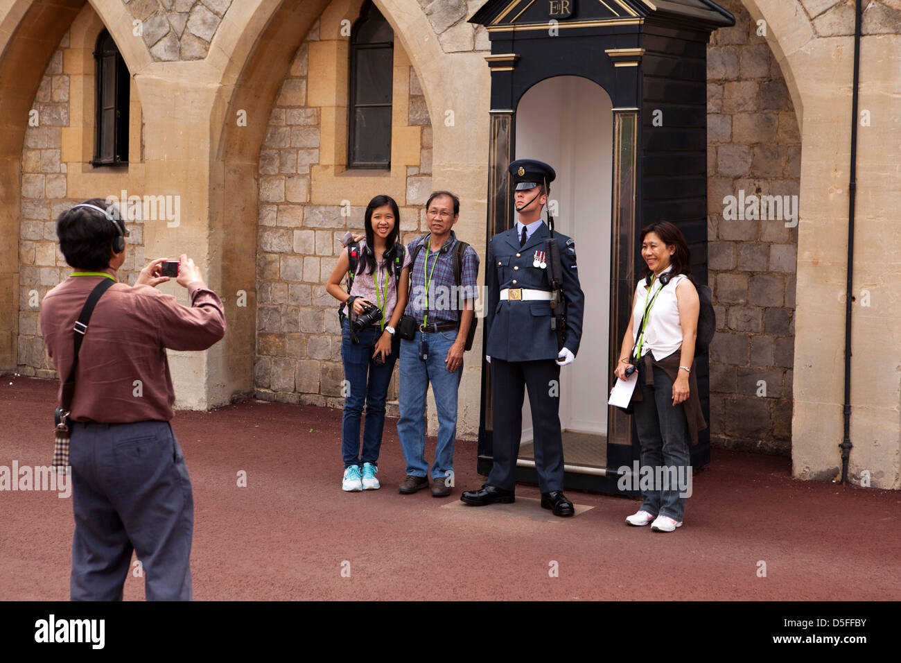 Inghilterra, Berkshire, Windsor Castle Hill, orientale turisti in posa con la Royal Air Force reggimento guardsman Foto Stock