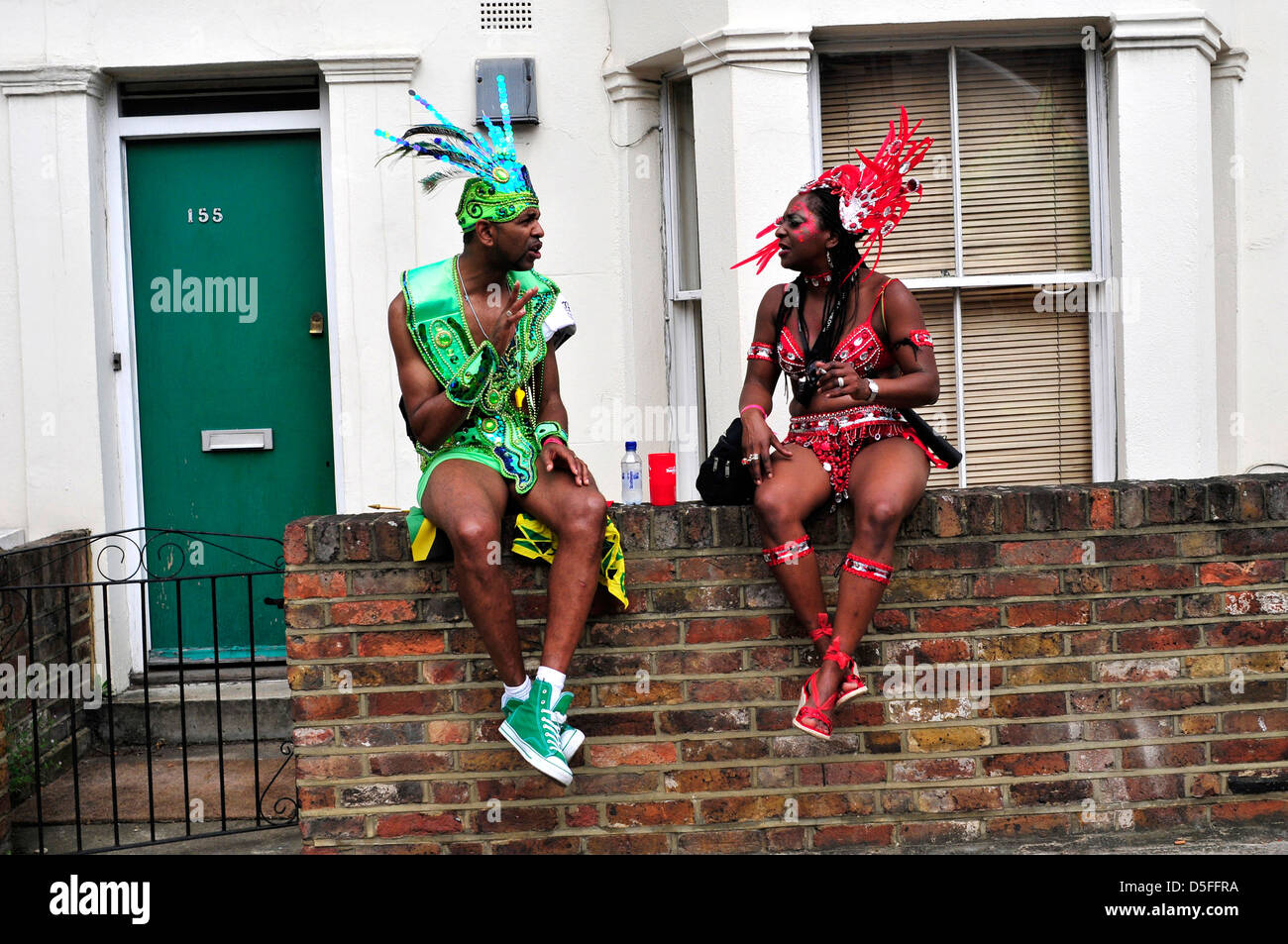 Due interpreti parlando mentre sono in attesa di unirsi a loro la posizione di flottazione per iniziare. Carnevale di Notting Hill. Londra, Regno Unito Foto Stock