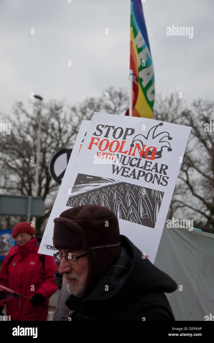 Aldermaston, Berkshire, Regno Unito. Il 1 aprile 2013. Un protestor detiene una targhetta dicendo 'stop ingannare con armi nucleari". Vi sono state proteste presso i vari ingressi alle armi atomiche stabilimento in Aldermaston, per protestare contro la Gran Bretagna di armi nucleari dell'impianto. Credito: Nelson Pereira / Alamy Live News Foto Stock