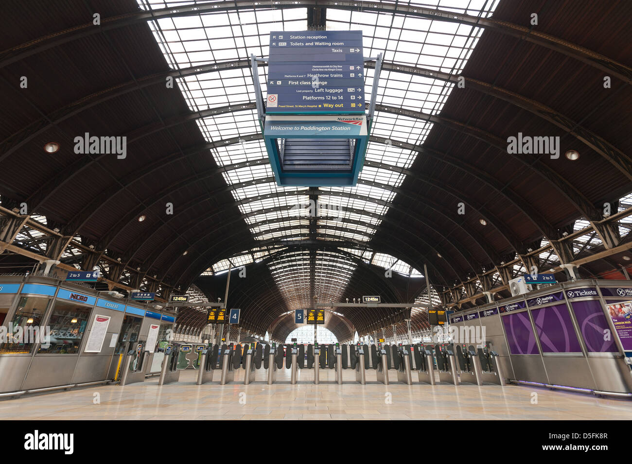 Fila di moderne barriere di ticket in contrasto con il vecchio formale di struttura di vetro e acciaio che dell'trainshed rood e atrio moderno Foto Stock