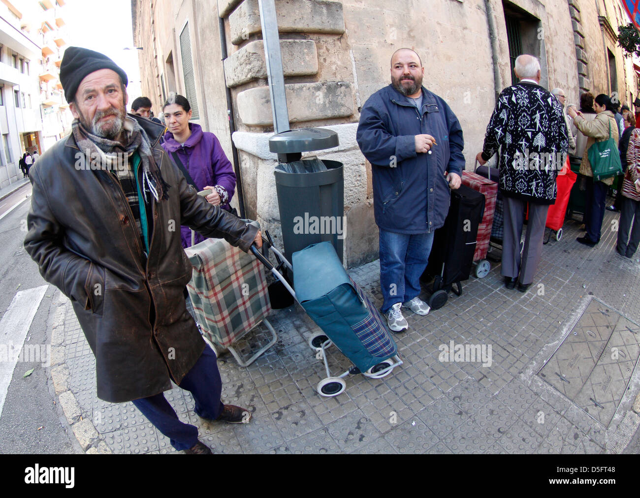 A disoccupati o a bassa risorse persone attendere alla porta di un centro di carità per un sacco di beni. Foto Stock