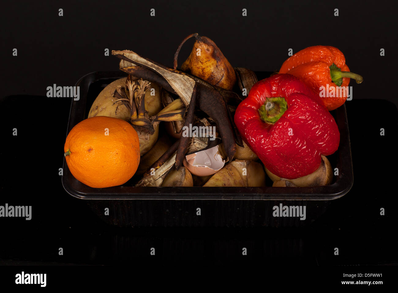 Marciume la frutta e la verdura con uno sfondo nero Foto Stock