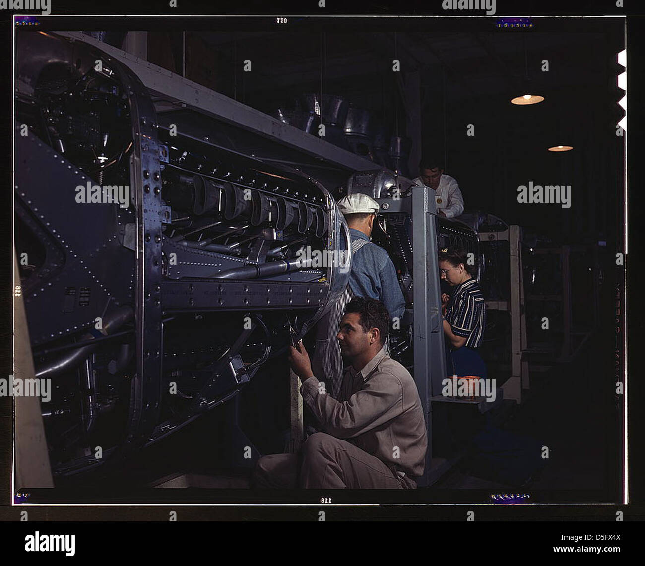 Questa immagine del 1942 mostra i dipendenti della North American Aviation di Inglewood, California, che assemblano la calandra per i motori Allison utilizzati negli aerei da caccia P-51 durante la seconda guerra mondiale. La foto cattura gli sforzi industriali in tempo di guerra e i contributi alla tecnologia aeronautica. Foto Stock