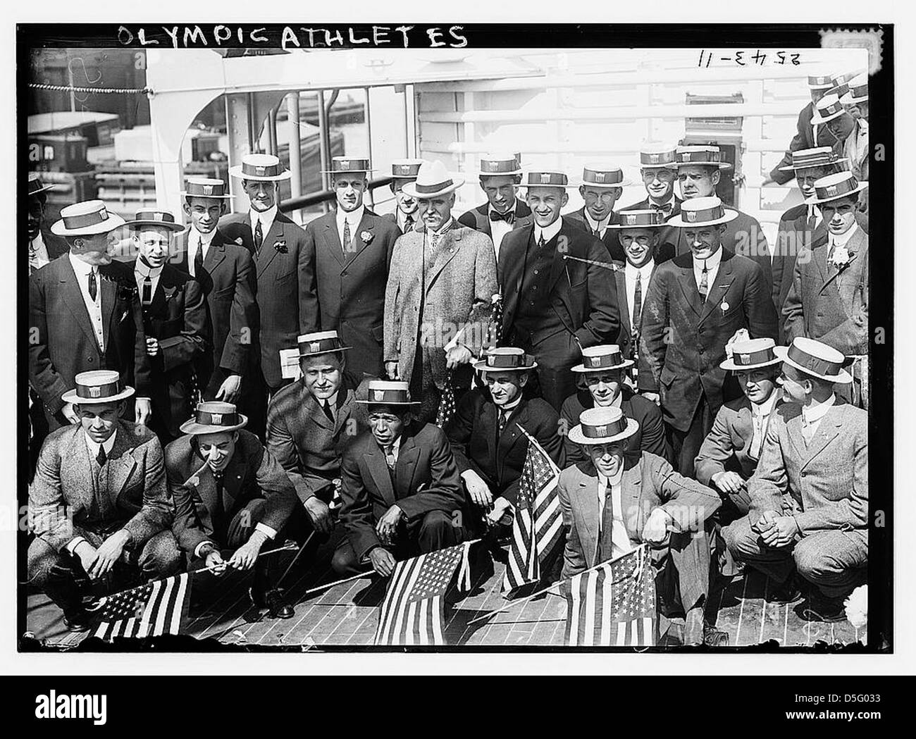 Gli atleti olimpici americani sono fotografati a bordo della S.S. Finland il 14 giugno 1912, mentre si imbarcano per Stoccolma, Svezia, per competere alle Olimpiadi estive del 1912. Gli atleti, con le bandiere americane in mano, sono visti nel loro abbigliamento formale, simboleggiando l'orgoglio e l'emozione di rappresentare gli Stati Uniti all'evento sportivo internazionale. Foto Stock