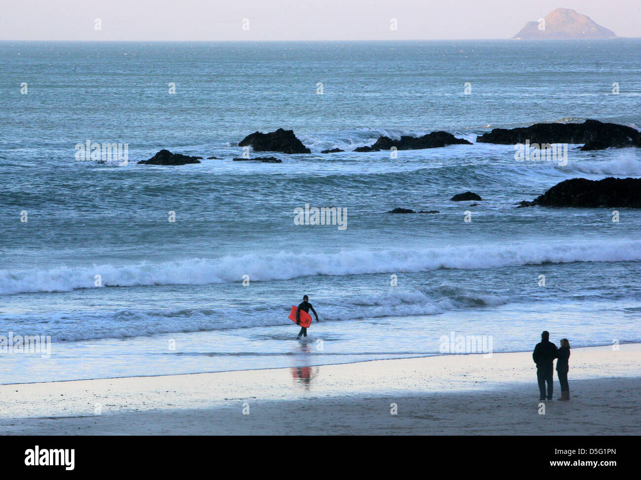 Surfer e giovane a Trevaunance Cove, Sant Agnese, Cornwall, Inghilterra. Foto Stock