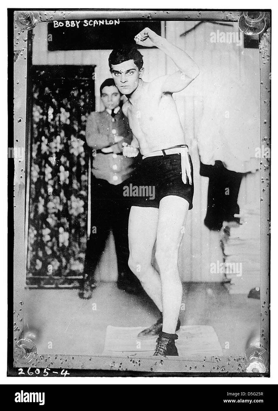 Questa immagine mostra Bobby Scanlon, un pugile, in azione durante un combattimento. Conosciuto per le sue capacità atletiche e pugilato, Scanlon fu una figura di spicco nel mondo della pugilato all'inizio del XX secolo. Foto Stock Questa immagine mostra Bobby Scanlon, un pugile, in azione durante un combattimento. Conosciuto per le sue capacità atletiche e pugilato, Scanlon fu una figura di spicco nel mondo della pugilato all'inizio del XX secolo. Foto Stock