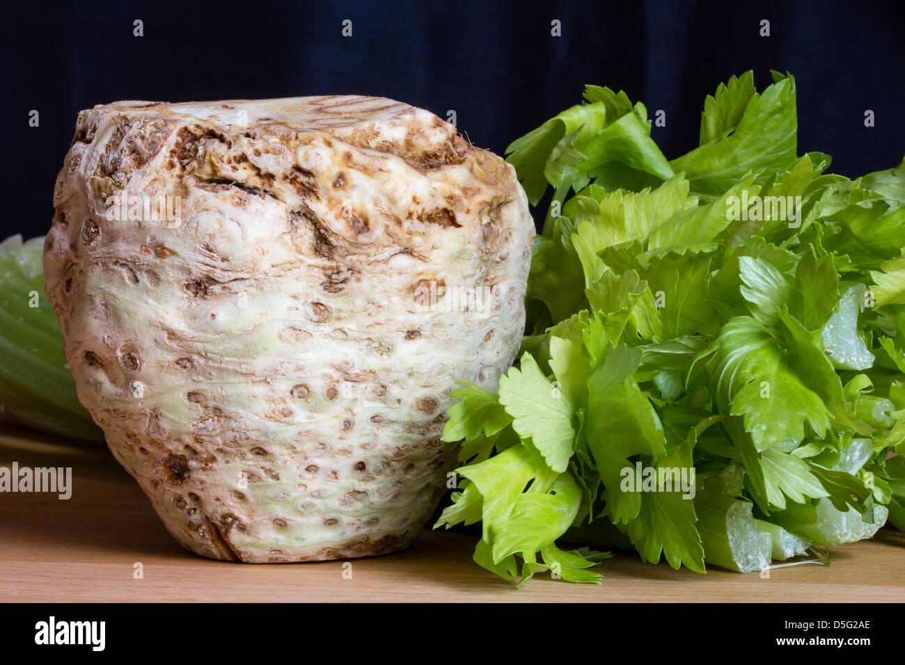 Fresco di radice di sedano con foglie su un tavolo di legno Foto Stock