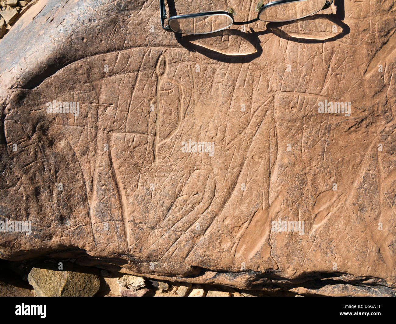 Occhiali preistorica scolpite incisioni rupestri che mostra scala a Oued Mestakou sulla Tata ad Akka road in Marocco. Foto Stock