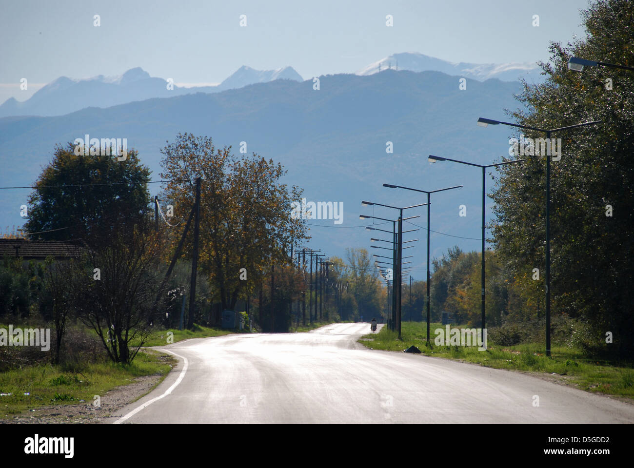 Strada che conduce verso alcune montagne Foto Stock
