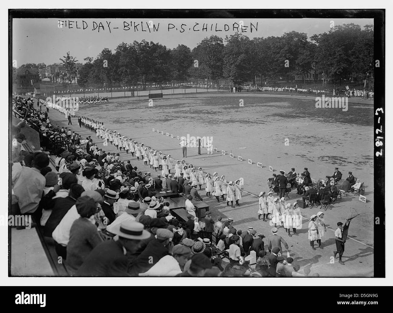 Questa fotografia mostra i bambini che partecipano a una giornata di campo al Brooklyn Athletic Field di New York. L'evento presenta un pubblico di spettatori e partecipanti impegnati in varie attività atletiche. Foto Stock Questa fotografia mostra i bambini che partecipano a una giornata di campo al Brooklyn Athletic Field di New York. L'evento presenta un pubblico di spettatori e partecipanti impegnati in varie attività atletiche. Foto Stock