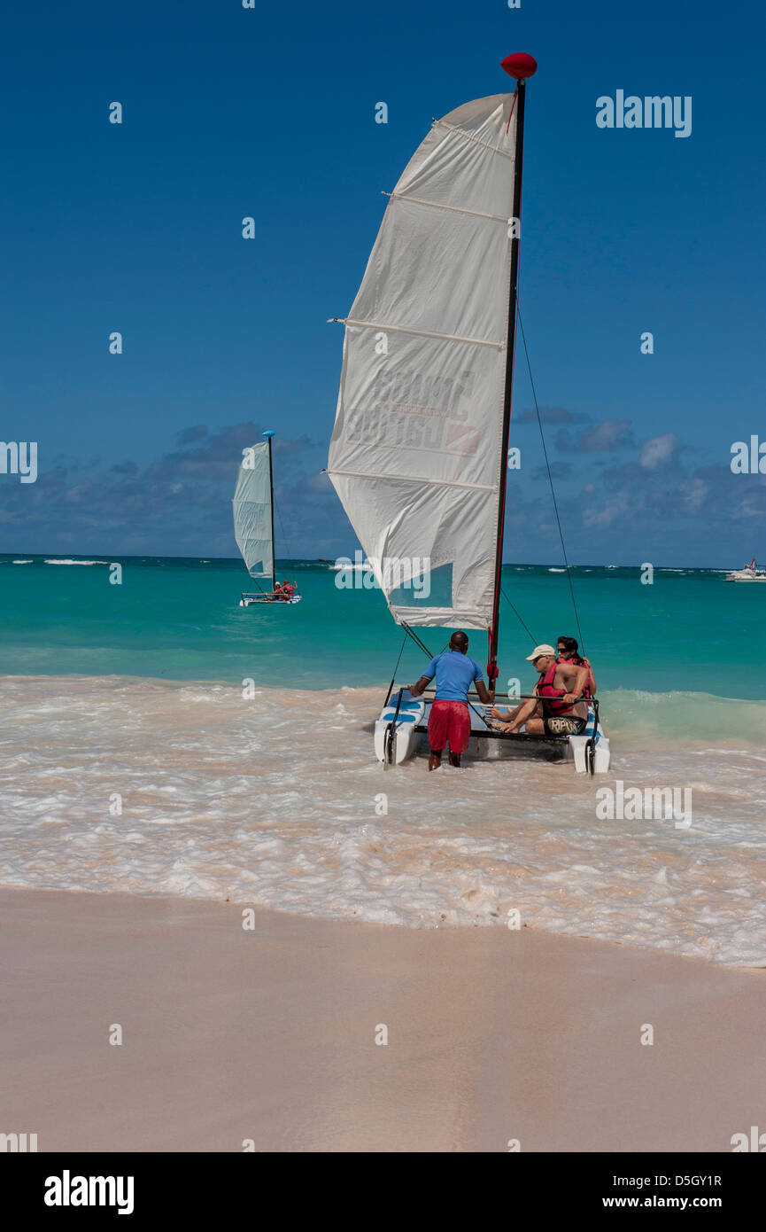 Repubblica Dominicana, Punta Cana, Higuey, Bavaro, Bavaro Beach, coppia giovane e barca a vela Foto Stock
