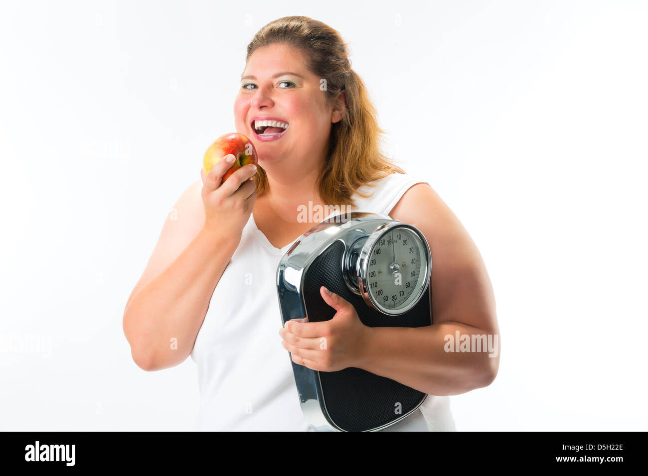 La dieta e il peso, obesi giovane donna con scala sotto il suo braccio e Apple Foto Stock