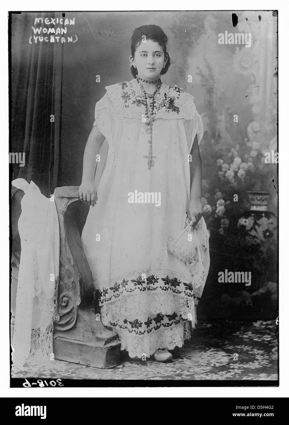 Una donna messicana di Yucatán viene fotografata con un abbigliamento tradizionale, tra cui perline e un abito da sposa ricamato. L'immagine evidenzia il significato culturale e storico dell'abbigliamento e dei costumi di Yucatán. Foto Stock