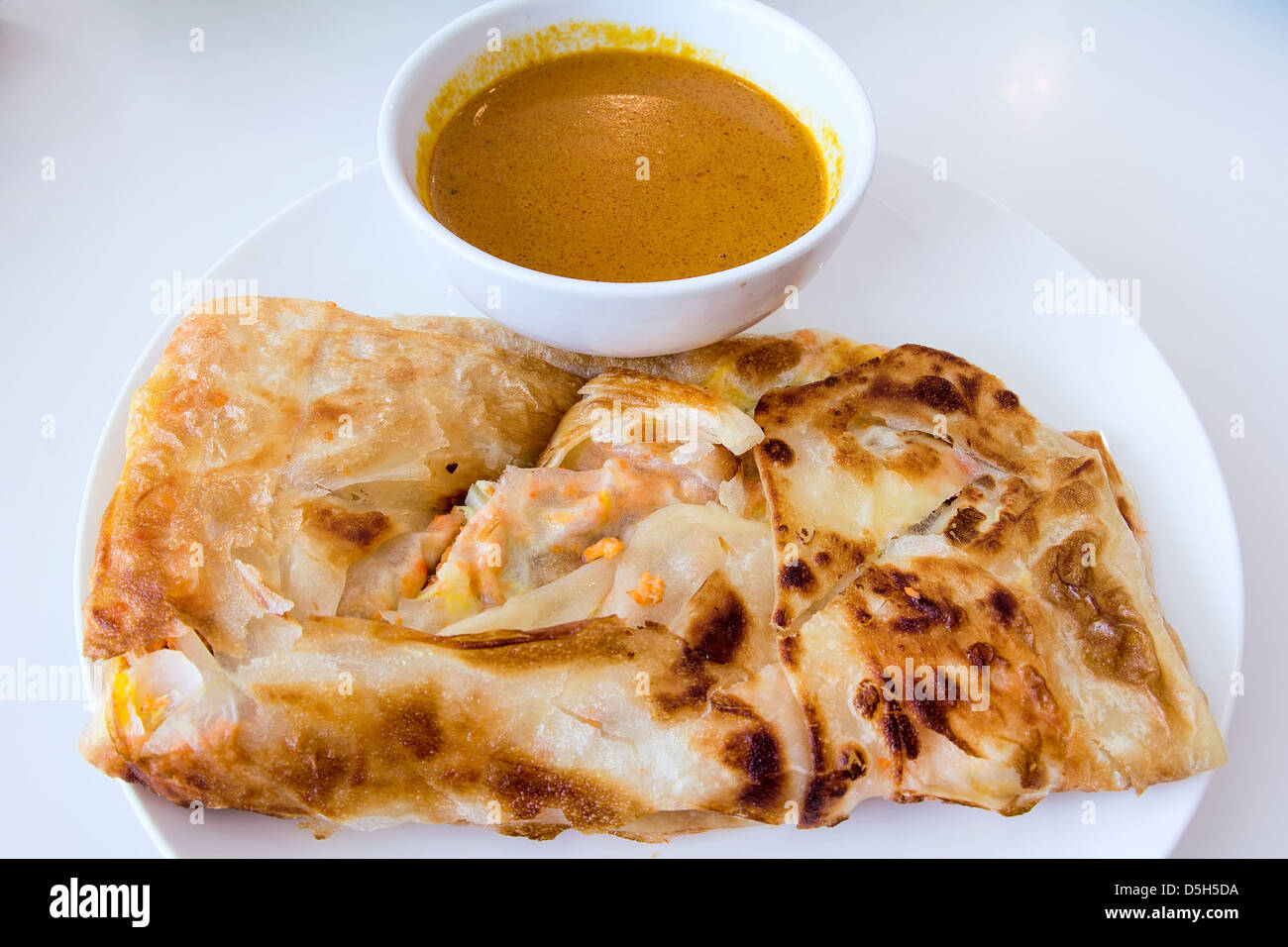 Indian Roti Prata con carne di pollo e salsa al curry Foto Stock