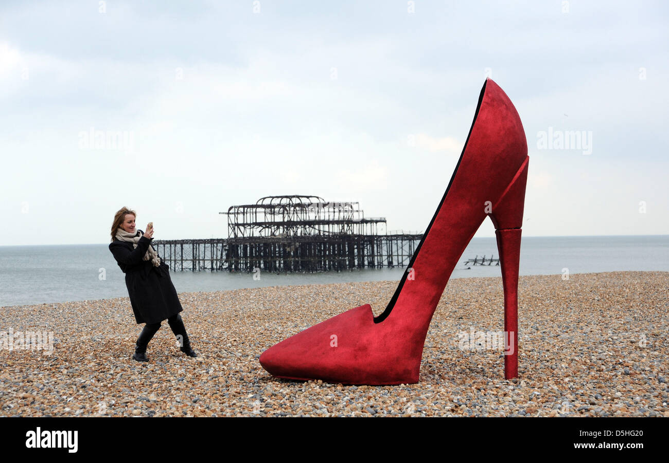 Un gigante rosso stiletto scarpa causato scalpore per la mattina presto i  corridori e i passanti sul lungomare di Brighton oggi quando è apparso come  parte di Churchill Square Shopping Centre se