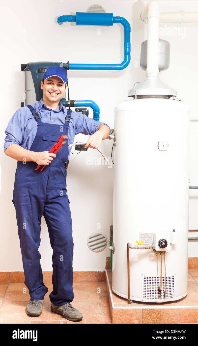 Sorridendo Il tecnico di riparazione di una caldaia Foto Stock