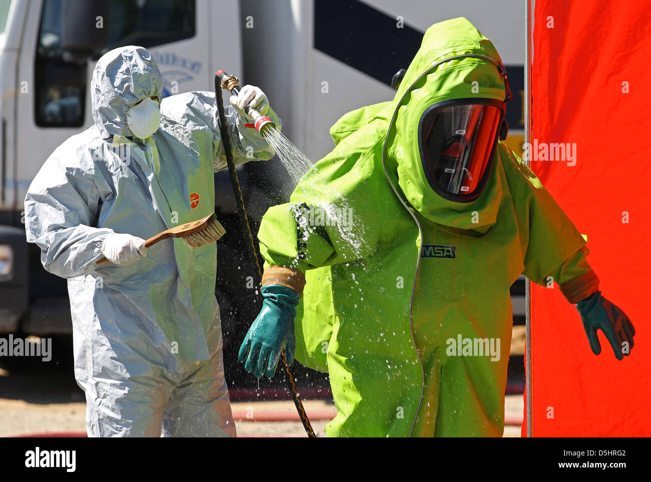 I vigili del fuoco in speciali tute protettive recuperare perde contenitori per prodotti chimici riempiti con i perossidi organici da un carrello in Teterow, Germania, 17 giugno 2010. Il trasportatore è stato arrestato dalla polizia a causa della fuoriuscita di fluidi. Le forze speciali dei vigili del fuoco ha iniziato il recupero dopo tre poliziotti sono stati feriti quando viene inalato, il gas chimici. Foto: BERND WUESTNECK Foto Stock