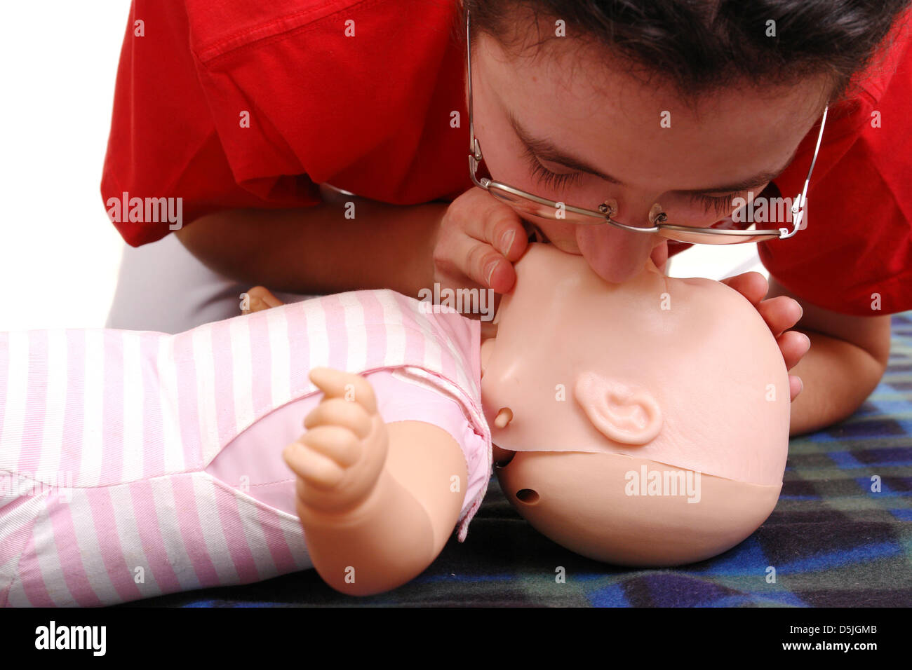 Primo soccorso istruttore dimostrando la respirazione artificiale utilizzando manichino neonato Foto Stock