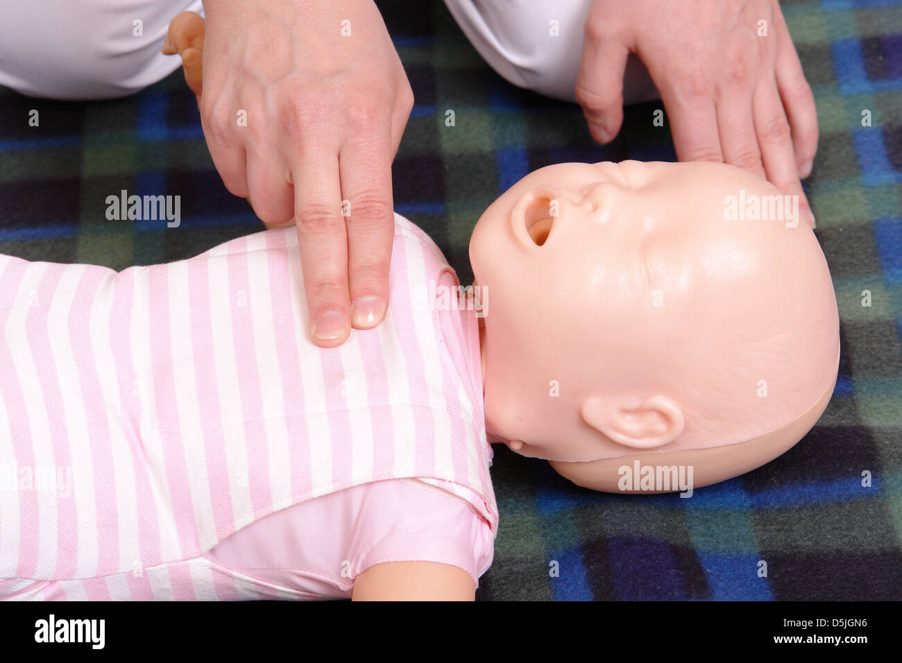 Primo soccorso istruttore dimostrando come controllare la vita infantile funzioni Foto Stock
