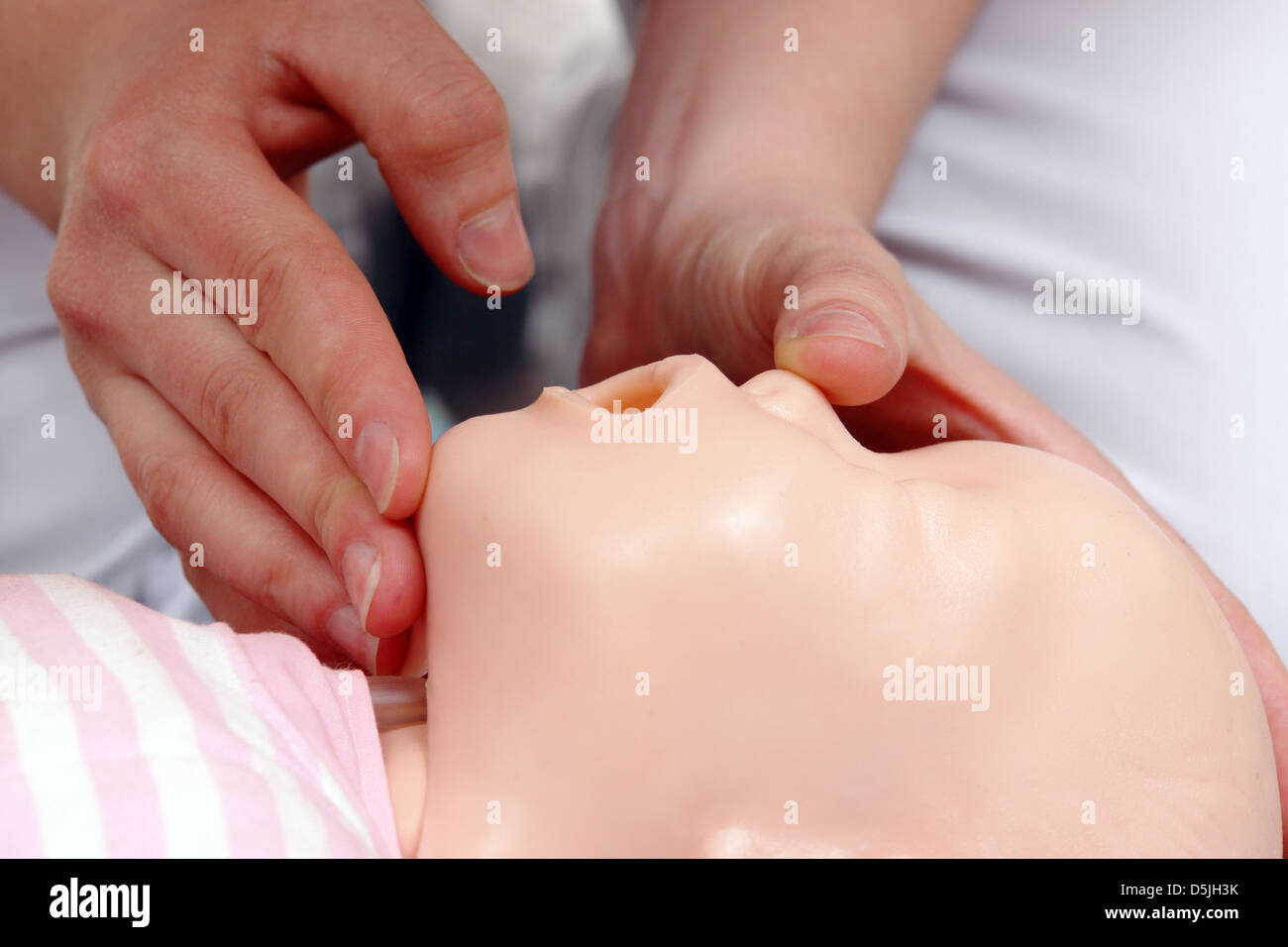 Primo soccorso istruttore che mostra come posizionare la testa per neonati prima di procedere con la bocca a bocca la rianimazione Foto Stock