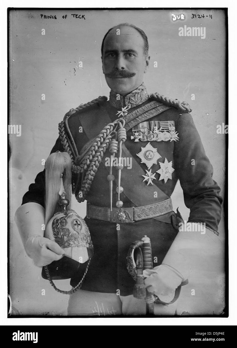 Questa fotografia raffigura il Principe di Teck in uniforme militare completa, adornato con spalline e medaglie e con una spada. L'aspetto del principe riflette la moda e lo stile militare del suo tempo, enfatizzando il suo status e la natura cerimoniale del suo ruolo. Foto Stock