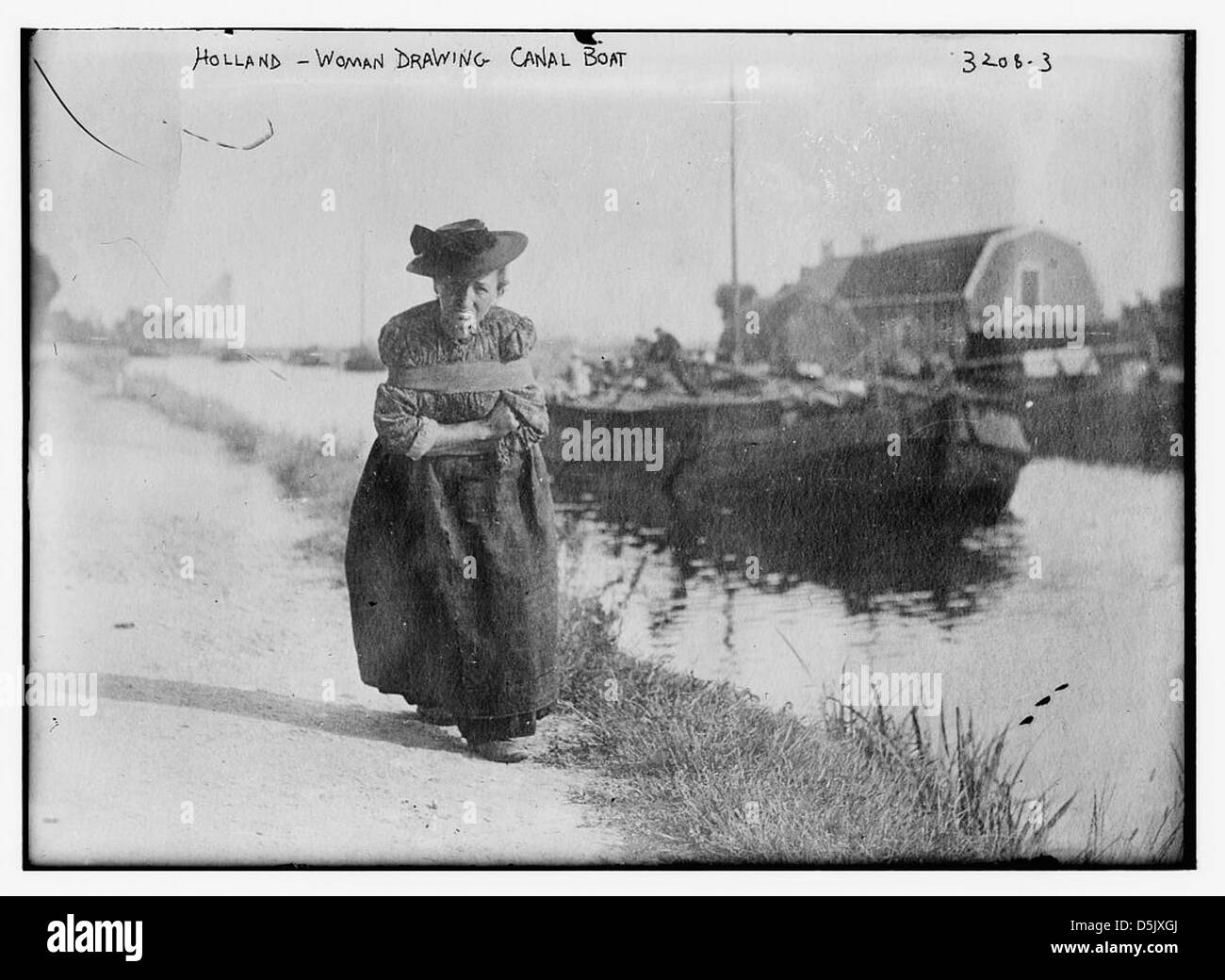 Una fotografia dall'Olanda che raffigura una donna che disegna una barca lungo il canale. L'immagine mostra i metodi di lavoro tradizionali utilizzati nel trasporto dei canali olandesi. Foto Stock