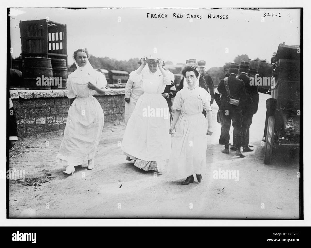 Le infermiere della Croce Rossa francese assistono i soldati durante la prima guerra mondiale. Vestite con uniformi bianche, camminavano all'aperto per fornire assistenza ai feriti, mostrando il loro ruolo essenziale nell'assistenza infermieristica in tempo di guerra. Foto Stock