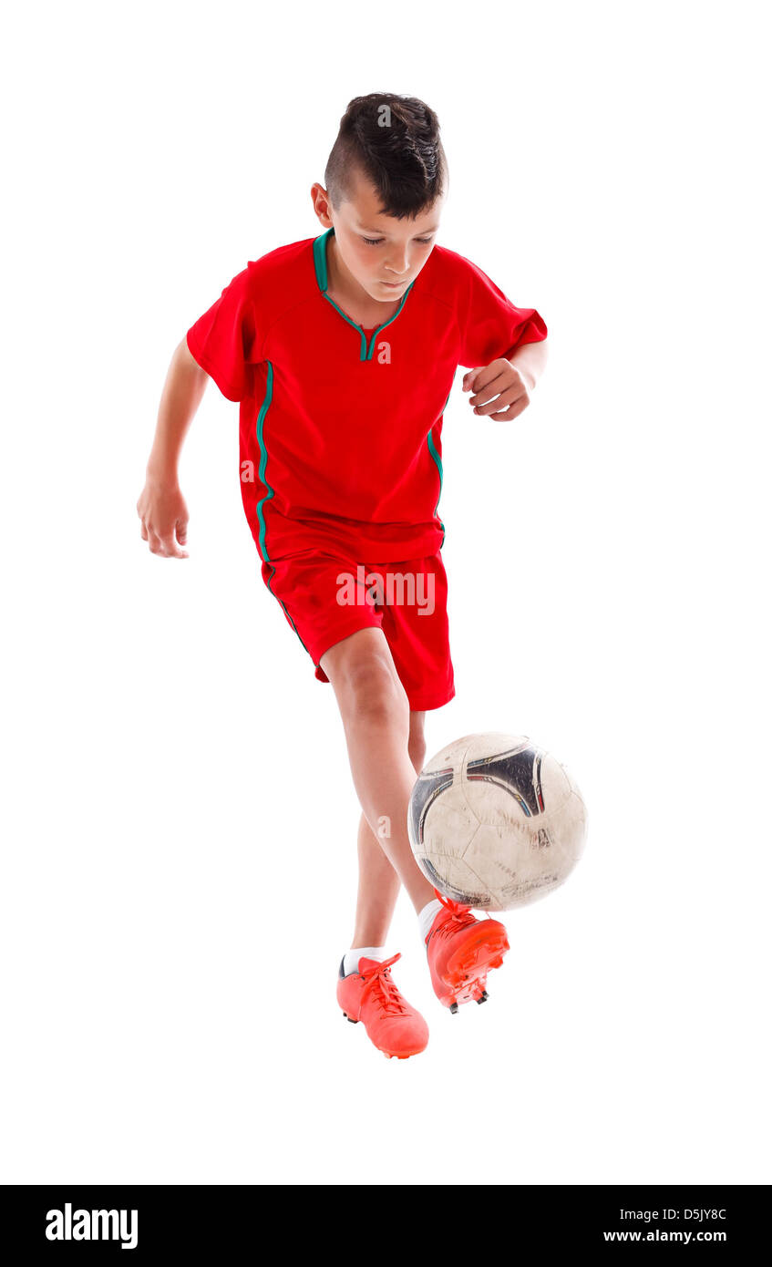 Soccer kid in rosso uniforme di giocare con il pallone da calcio - studio shot Foto Stock