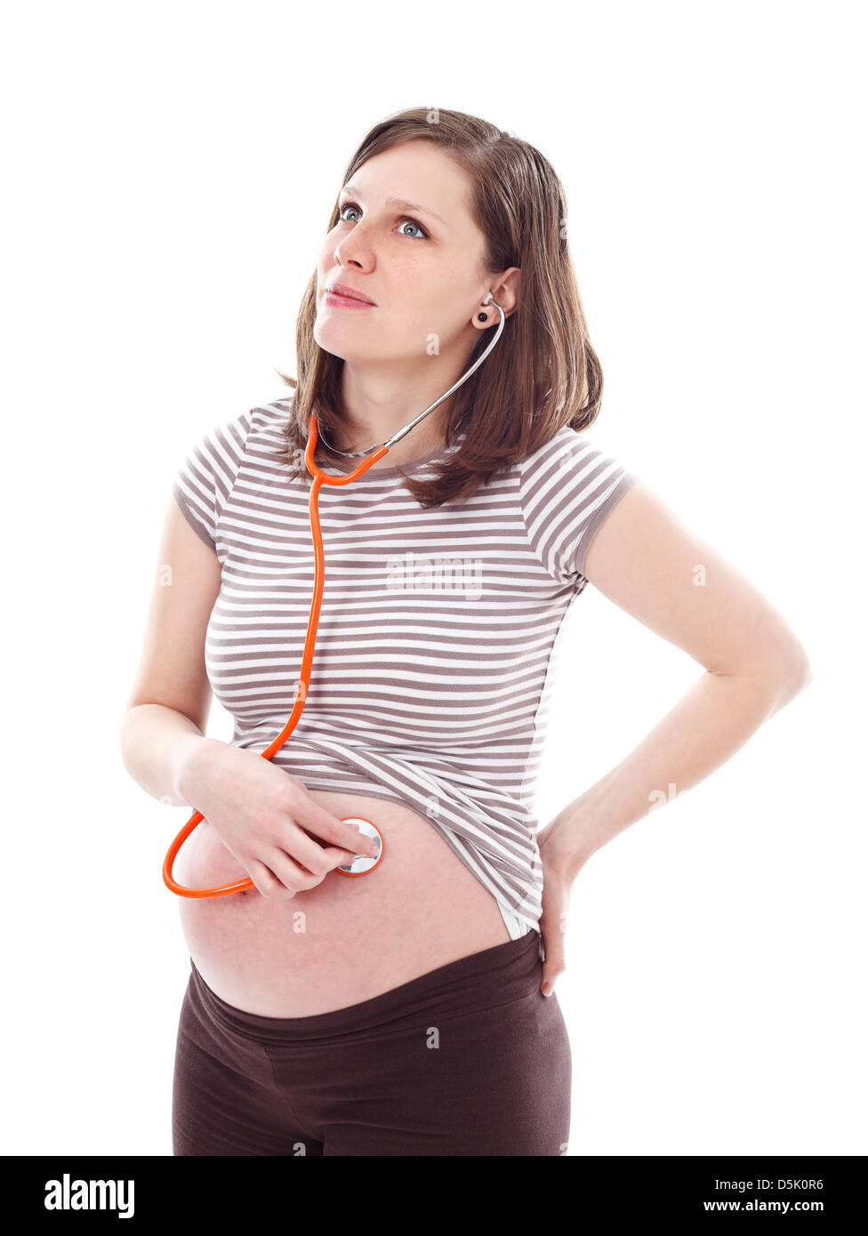 Giovane donna incinta ascolto di ventre con uno stetoscopio isolati su sfondo bianco Foto Stock