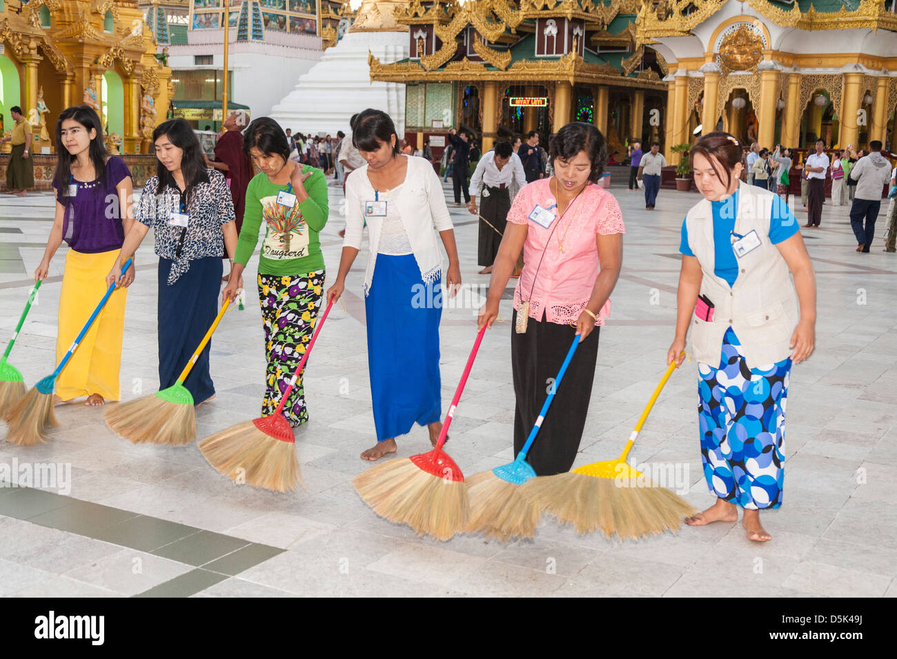 Le donne di spazzamento pavimento piastrellato in corrispondenza di Shwedagon pagoda Yangon (Rangoon), Myanmar (Birmania) Foto Stock