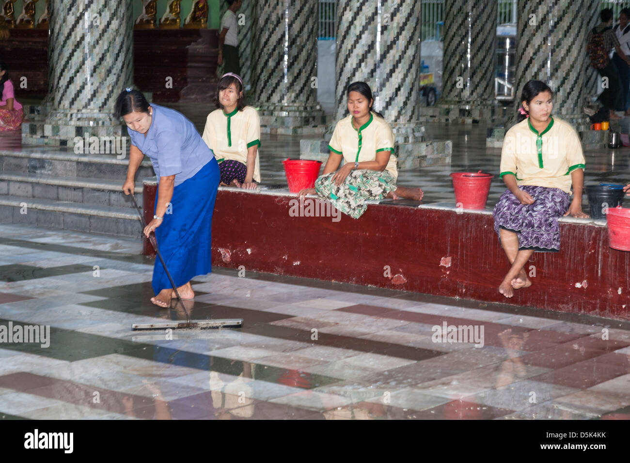 Donna di pulizia pavimento piastrellato in corrispondenza di Shwedagon pagoda Yangon (Rangoon), Myanmar (Birmania) Foto Stock