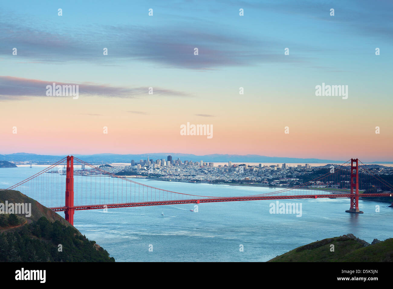 Golden Gate Bridge all'alba con skyline di San Francisco e nuvole in movimento Foto Stock