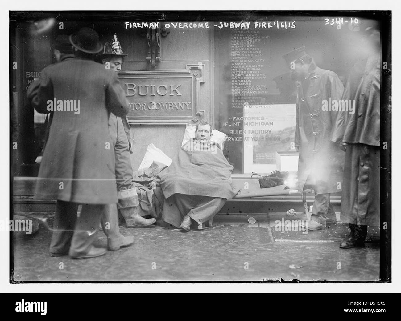 Questa fotografia cattura un vigile del fuoco sconfitto durante un incendio della metropolitana a New York il 6 gennaio 1915. L'incendio si verificò nella zona di Broadway di Manhattan vicino a una concessionaria Buick e coinvolse il New York City Fire Department. Foto Stock