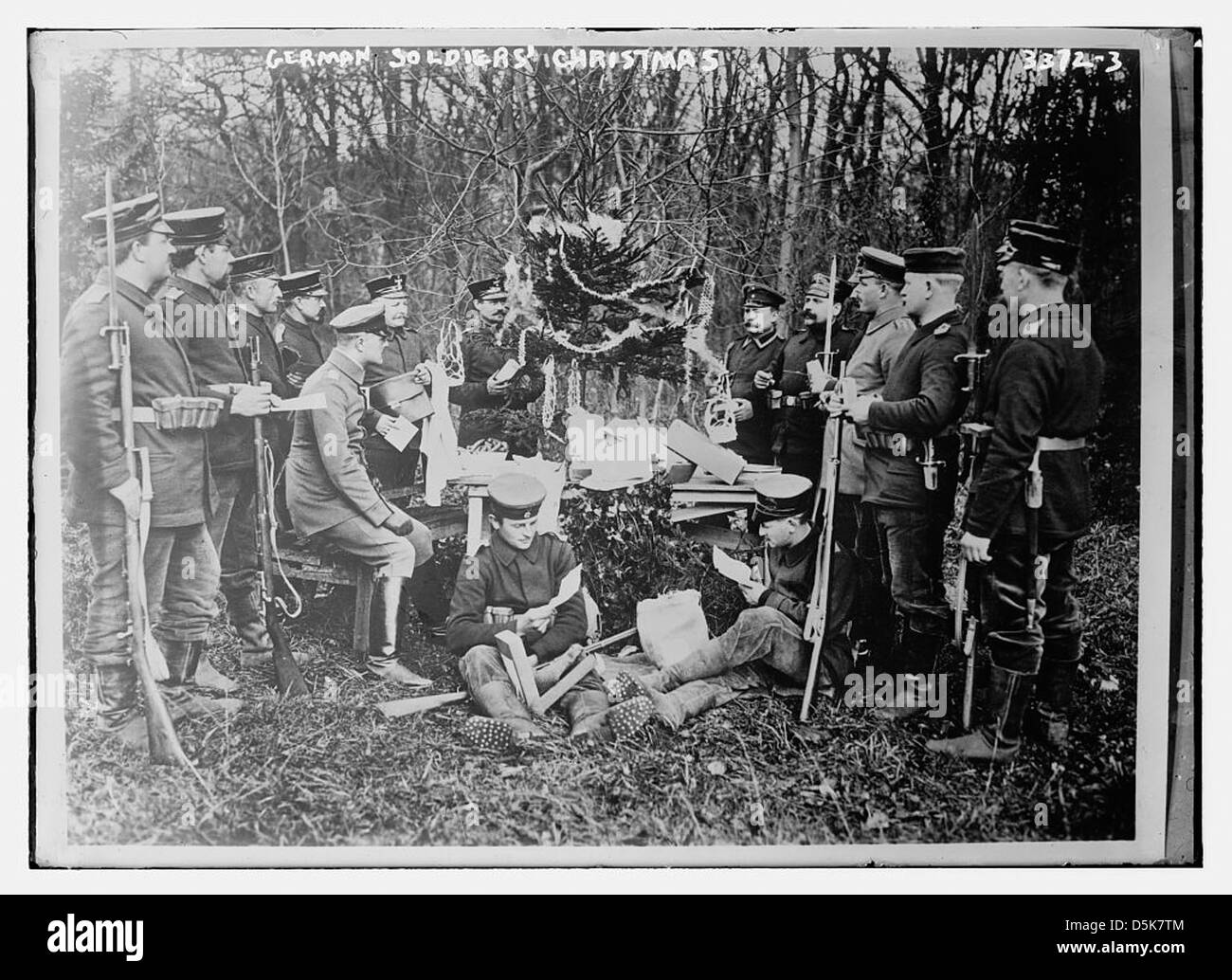 Questa fotografia raffigura un soldato tedesco che celebra il Natale durante la prima guerra mondiale. Il soldato è visto in un ambiente di foresta, circondato da regali di Natale e un albero, catturando un raro momento di tregua durante la guerra. Foto Stock