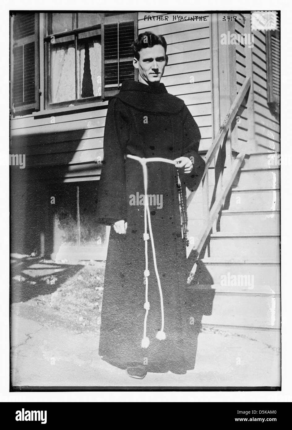 Un ritratto di padre Giacinthe, un membro del clero, catturato in abiti religiosi con un rosario. L'immagine riflette il ruolo del clero nella vita religiosa, mostrando l'abbigliamento e la natura solenne della vocazione religiosa. Foto Stock