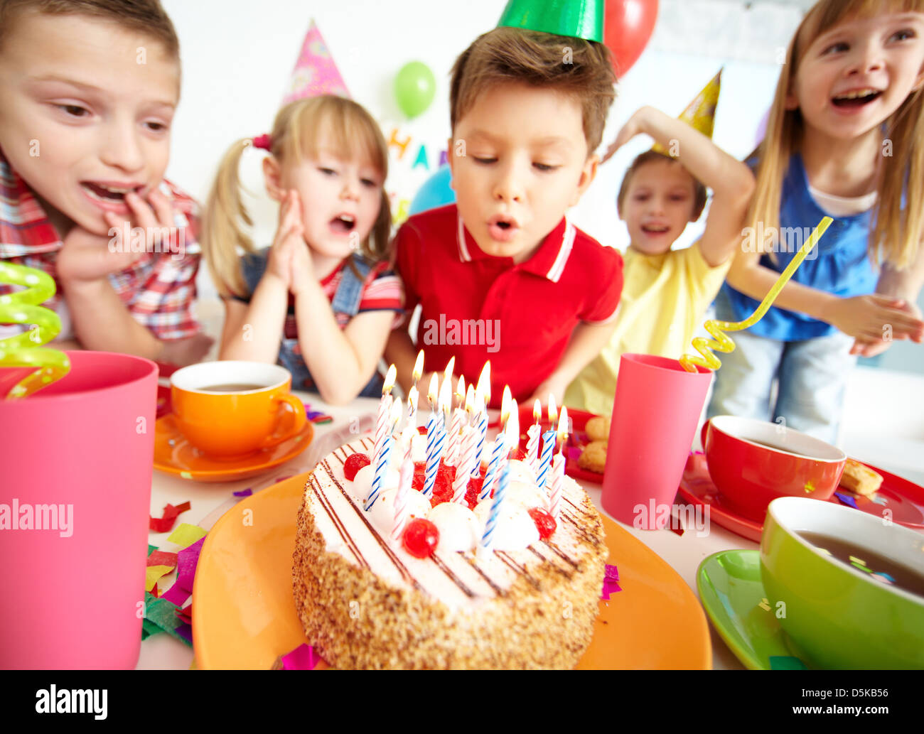 Un gruppo di ragazzi adorabili guardando alla torta di compleanno con candele Foto Stock