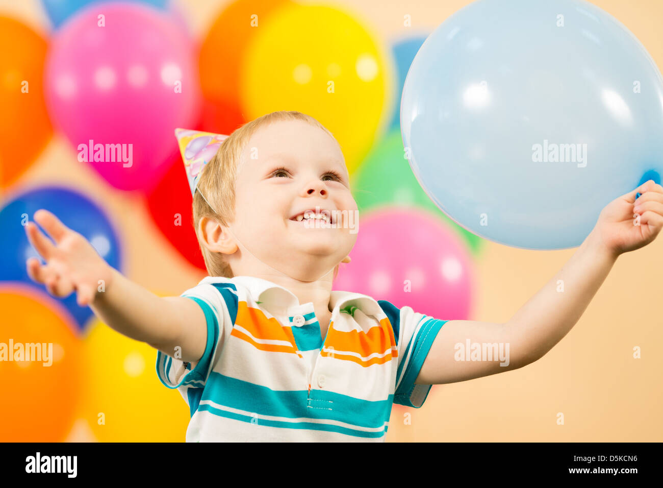 Gioiosa kid boy con palloncini sulla festa di compleanno Foto Stock