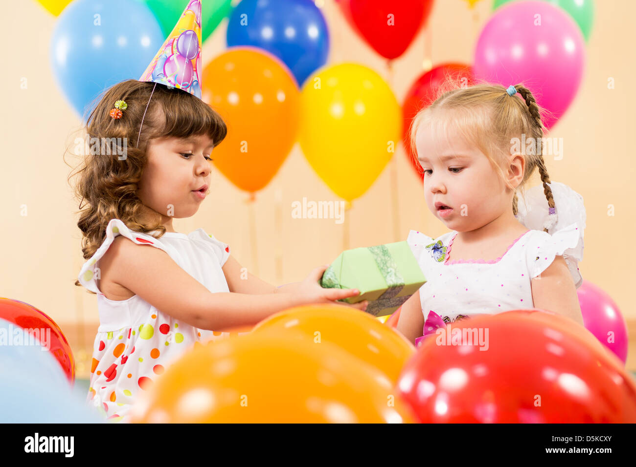 Piuttosto i bambini con palloncini colorati e doni sulla festa di compleanno Foto Stock