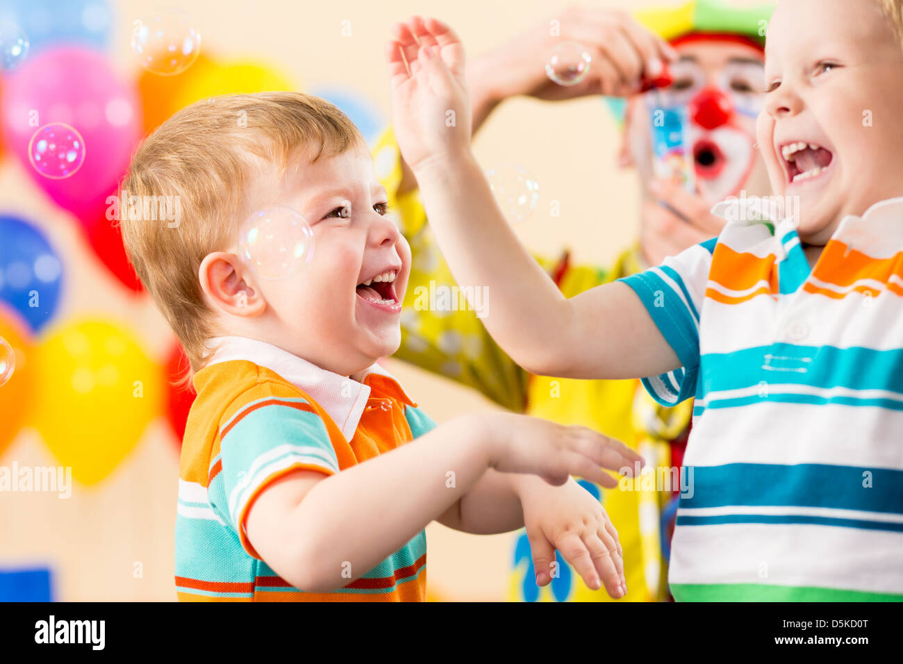 Bambini gioiosi con clown sulla festa di compleanno Foto Stock