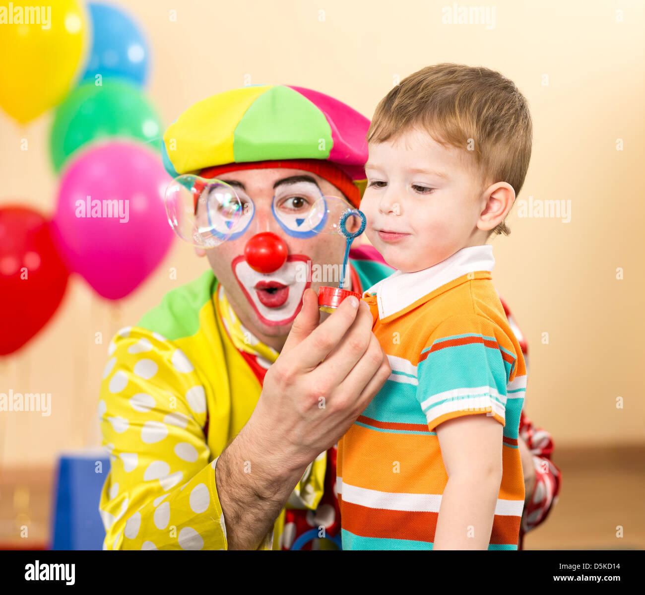 Gioiosa kid con clown sulla festa di compleanno Foto Stock