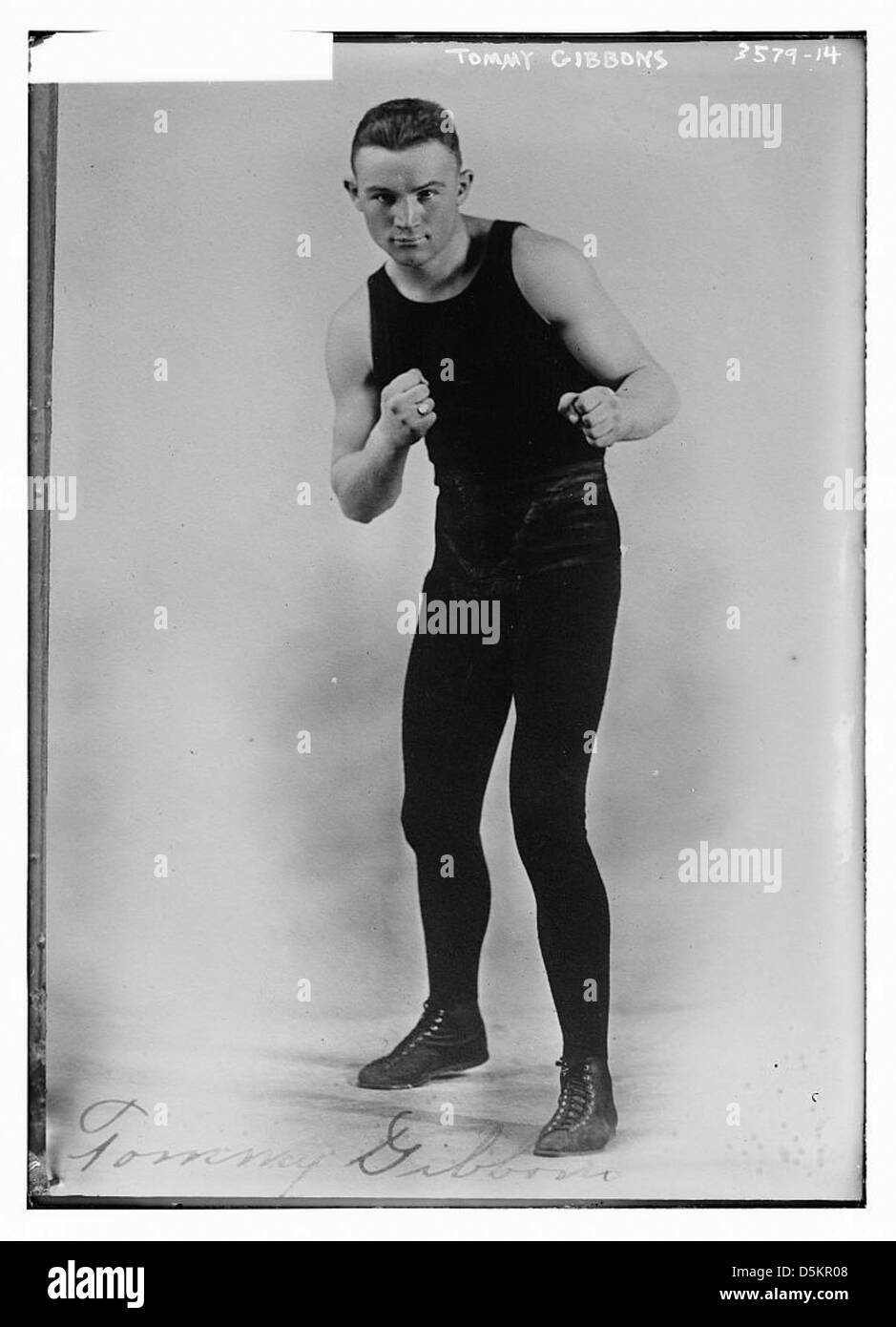 Questa fotografia raffigura Tommy Gibbons, un atleta e pugile, catturato in un momento di intensa messa a fuoco sul ring di pugilato. Foto Stock
