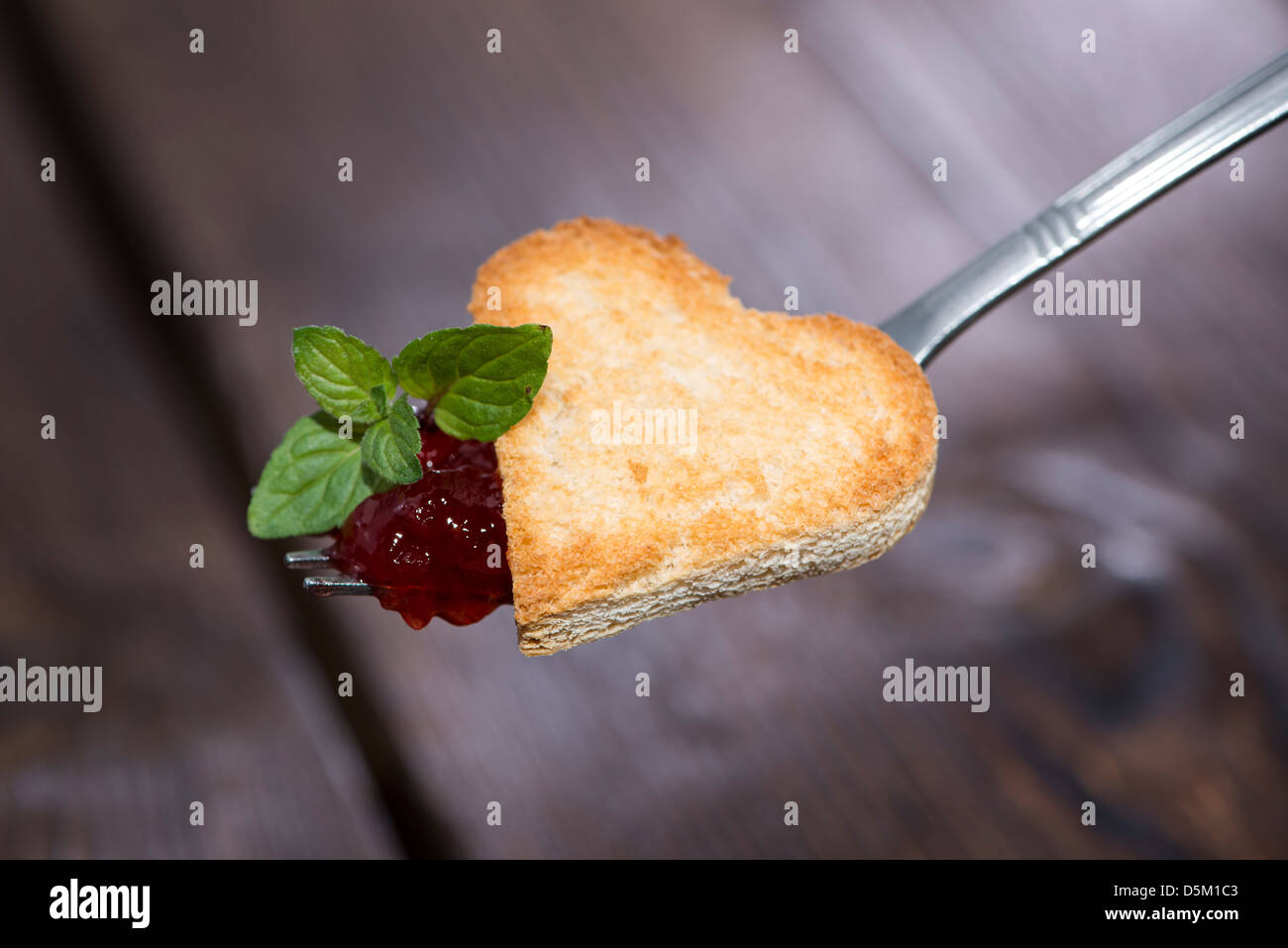 Cuore di toast con marmellata di fragola su una forcella Foto Stock