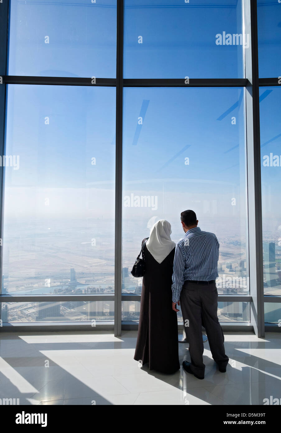 I turisti che si affacciava su Dubai da in alto a piattaforma di osservazione in Burj Khalifa la struttura più alto del mondo a Dubai Uni Foto Stock
