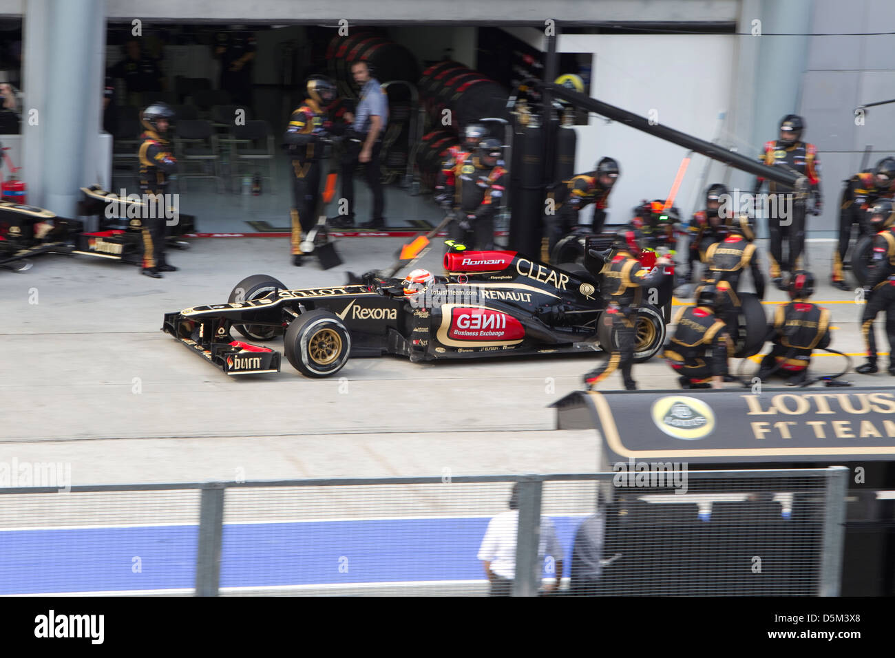 Romain Grosjean del team Lotus F1 esce dalla sua buca dopo la sostituzione di un pneumatico a Malaysian GP di F1 Foto Stock